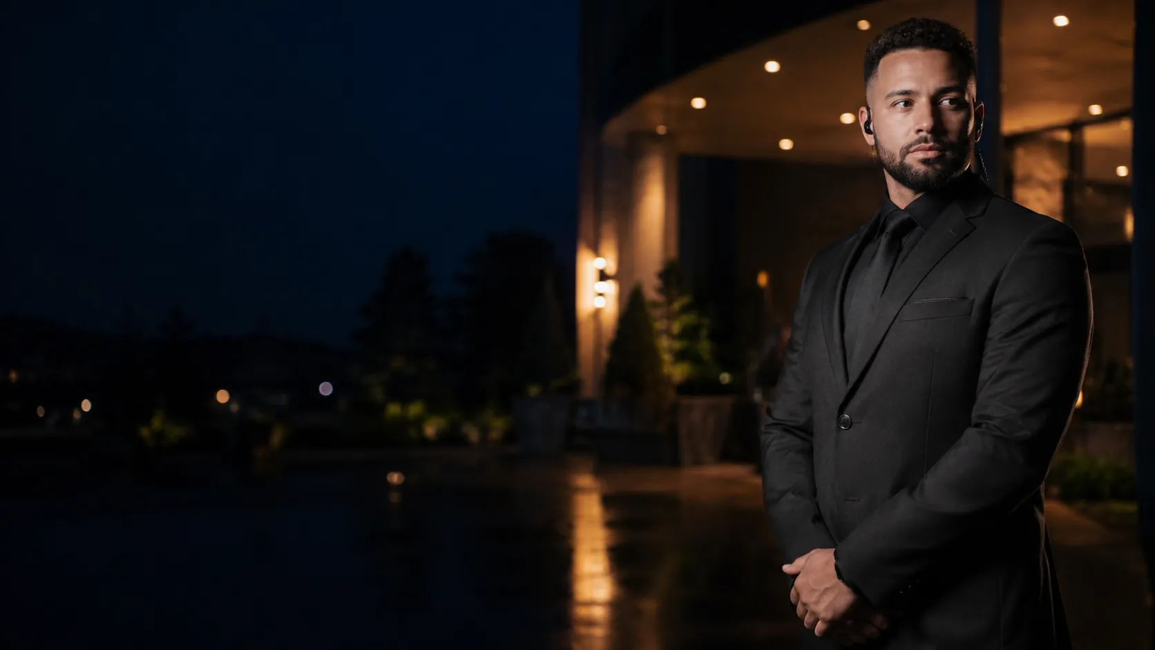 A SilverBack Security guard standing watch at a property entrance at night